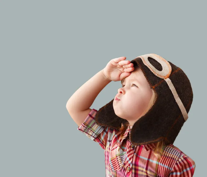 Young pupil in a pilot hat looking ahead